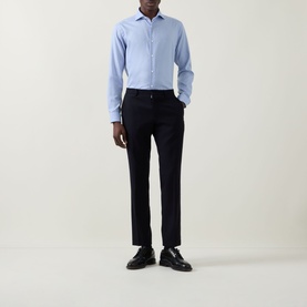 Model wearing Eton Signature Oxford Shirt in light blue with wide spread collar, styled with navy tapered trousers and black loafers.