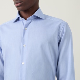 Model wearing Eton Signature Oxford Shirt in light blue, showing wide spread collar and front button fastening in a close-up crop shot.