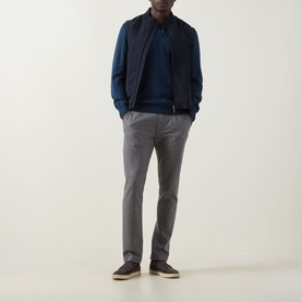 Model wearing Eton Lana Technical Gilet in navy blue over a navy jumper, styled with grey trousers and dark shoes.
