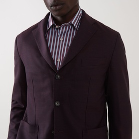 Model wearing Eton Lana Tech Single-Breasted Blazer in dark red with notched lapels and patch pockets, styled with a striped shirt.
