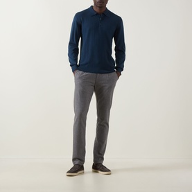 Model wearing Eton Chevron Structure Polo Shirt in mid blue with long sleeves, paired with grey trousers and dark loafers.