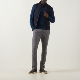 Model wearing Eton Chevron Structure Polo Shirt in Mid Blue, styled with a navy gilet and grey trousers, white trainers.
