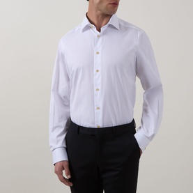 Model wearing Eton Solid Single-Cuff Shirt in white cotton, cut-away collar, gold buttons, long sleeves, styled with black trousers.