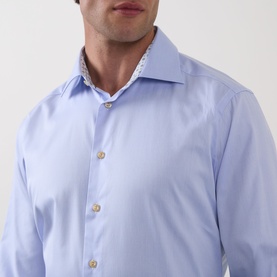 Model wearing Eton Solid Single-Cuff Shirt in light blue with cut-away collar, gold buttons, and geometric patterned inner collar detail.
