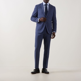Model wearing Eton Prince of Wales Check Shirt in light blue, styled with a navy suit, blue tie, and black Oxford shoes.