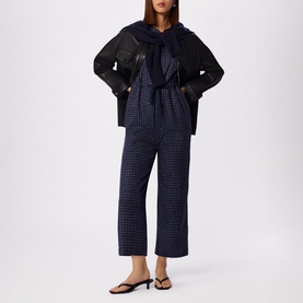 Model wearing WHISTLES Grid Check Drawstring Jumpsuit &ndash; full-length view styled with black jacket and sandals