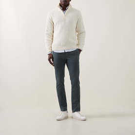 Model wearing Hugo Boss Orange Open Green cotton chino trousers, styled with a cream half-zip knit and white trainers.