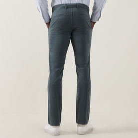 Model wearing Hugo Boss Orange Open Green slim-fit chino trousers, styled with a light blue shirt and white trainers, rear view.