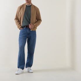 Model wearing Hugo Boss Orange Open Green cotton-cashmere crew neck, styled with camel bomber jacket, blue jeans and white trainers.