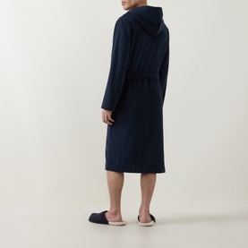 Model wearing Hugo Boss Logo Fleece Belted Robe in dark blue, hooded, long length, styled with navy slippers, rear view.