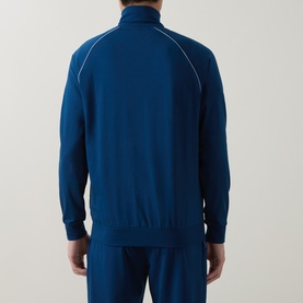 Model wearing Hugo Boss turquoise zip-up lounge top, rear view, white piped seam details, matching trousers visible
