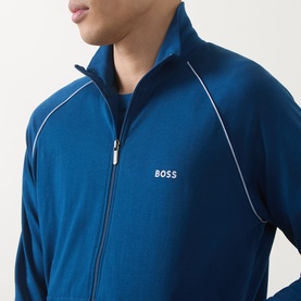Model wearing Hugo Boss turquoise zip-up loungewear top with white piping detail and gold-tone zip