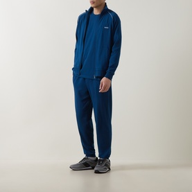 Model wearing Hugo Boss turquoise cotton zip-up lounge top with matching joggers and grey trainers