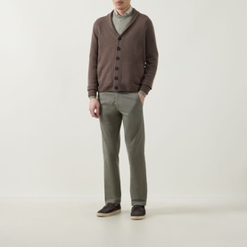 Model wearing John Smedley Rockford Shawl Cardigan in light brown, styled with sage green trousers and dark loafers.