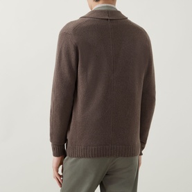 Model wearing John Smedley Rockford Shawl Cardigan in light brown, back view, styled with olive trousers
