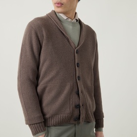 Model wearing John Smedley Rockford Shawl Cardigan in light brown with button fastening and ribbed trims, styled with green trousers