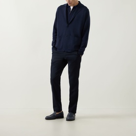 Model wearing John Smedley Narah Knit Cardigan in navy with notched lapels and patch pockets, styled with dark trousers and loafers.