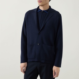 Model wearing John Smedley Narah Knit Cardigan in navy, featuring notched lapels and button fastening, styled over a navy shirt with dark trousers.