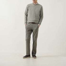 Model wearing John Smedley 15.Singular Knit Sweater in Thistle Drew, crew neck merino wool, styled with taupe trousers and dark loafers.