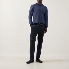 Model wearing John Smedley Winslow Textured Knit Sweater in Blueprint Midnight, styled with navy trousers and black leather shoes.