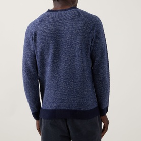 Model wearing John Smedley Winslow Textured Knit Sweater in Blueprint Midnight, showing rear view with ribbed crew neck and hem detailing.