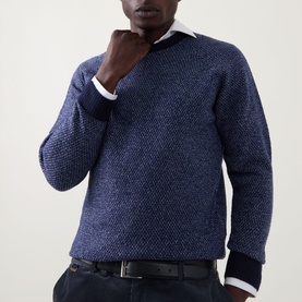 Model wearing John Smedley Winslow Textured Knit Sweater in Blueprint Midnight, crew neck, ribbed cuffs, styled with white shirt and dark trousers