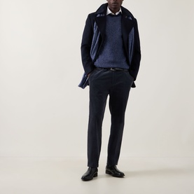 Model wearing John Smedley Winslow Textured Knit Sweater in Blueprint Midnight, styled with navy coat and tailored trousers