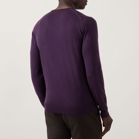 Model wearing John Smedley Lundy Extra Fine Knit Sweater in Velvet Plum, rear view showing crew neck, long sleeves and ribbed trims.