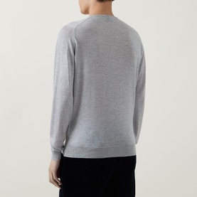 Model wearing John Smedley Lundy Extra Fine Knit Sweater in light grey, crew neck, long sleeves with ribbed cuffs, back view, paired with black