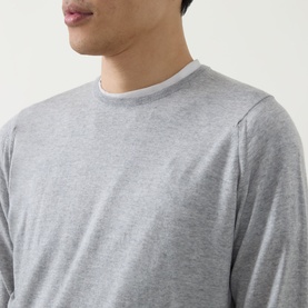 Model wearing John Smedley Lundy Extra Fine Knit Sweater in light grey, featuring crew neckline, long sleeves and ribbed trims