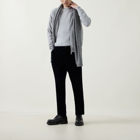 Model wearing John Smedley Lundy Light Grey Extra Fine Knit Crew Neck Sweater, styled with grey cardigan, black trousers and chunky black shoes.