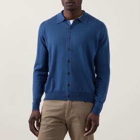 Model wearing John Smedley Tibor Fine Knit Polo Cardigan in Teal Firth, button front, polo collar, styled with beige chinos