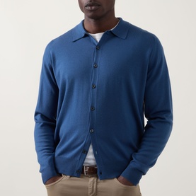 Model wearing John Smedley Tibor Fine Knit Polo Cardigan in Teal Firth, with polo collar and button front, styled with neutral trousers and tan belt.
