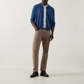 Model wearing John Smedley Tibor Fine Knit Polo Cardigan in Teal Firth, styled with white tee, beige chinos and black leather shoes.