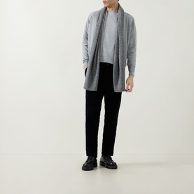 Model wearing John Smedley 16.Singular Extra Fine Knit Jacket in light grey with shawl collar, styled with black trousers and black shoes.
