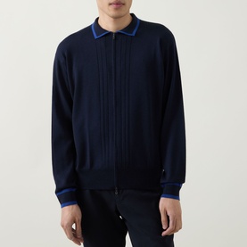 Model wearing John Smedley Albie Tipped Cardigan in navy, zip-through with flat collar, blue tipped trims, and ribbed details. Styled with dark