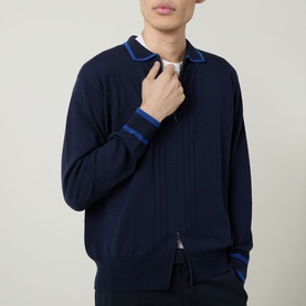 Model wearing John Smedley Albie Tipped Cardigan in navy, zip-through style with blue tipped collar and cuff stripe details, extra fine knit