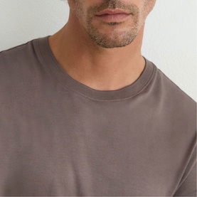 Model wearing Reiss mouse brown crew neck T-shirt, close-up of neckline and chest detail.