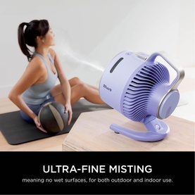 Shark FlexBreeze HydroGo Misting Fan in purple, compact desk-style design with misting function, shown in lifestyle setting with model on yoga mat
