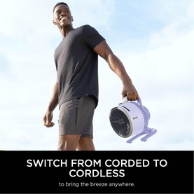 Model carrying Shark FlexBreeze HydroGo Misting Fan in purple, wearing grey t-shirt and shorts, with text overlay about cordless use