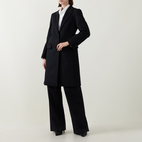 Model wearing Hugo Boss black wool coat with notched lapel, styled with white shirt and wide-leg black trousers