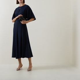 Model wearing Hugo Boss dark blue midi dress with flared sleeves and A-line skirt, styled with nude heels and small black clutch bag