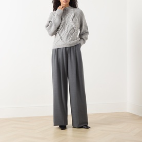 Model wearing Hugo Boss cable-knit wool-blend jumper in light grey, styled with wide-leg grey trousers and black loafers.