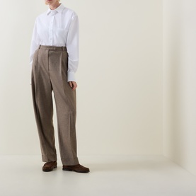 Model wearing Hugo Boss Saturday Patch Pocket Oversized Shirt in white with taupe wide-leg trousers and brown loafers.