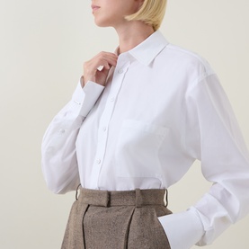 Model wearing Hugo Boss Saturday Patch Pocket Oversized Shirt in white, long sleeves, pointed collar, styled with brown tweed trousers