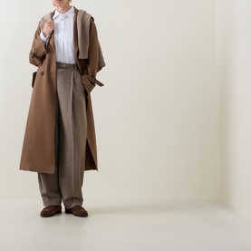 Model wearing Hugo Boss Saturday Patch Pocket Oversized White Shirt, styled with a camel oversized coat, wide-leg trousers and brown loafers.