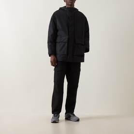 Model wearing Hugo black casual jacket with hood, styled with black cargo trousers and grey trainers