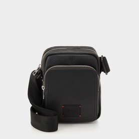 Hugo black crossbody bag with silver-tone zip hardware, front pocket, red logo patch, and adjustable black shoulder strap