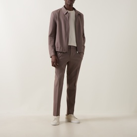 Model wearing Hugo Rust/Copper Suit Jacket in wool blend, styled with matching trousers and white polo shirt and trainers.