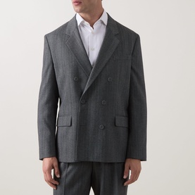 Model wearing Hugo dark grey double-breasted suit jacket with peak lapels, paired with matching trousers and white shirt.